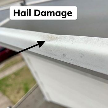 Arrow pointing to hail damage on a gutter