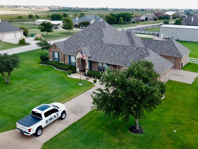 SWAT roofing white truck parked outside a house