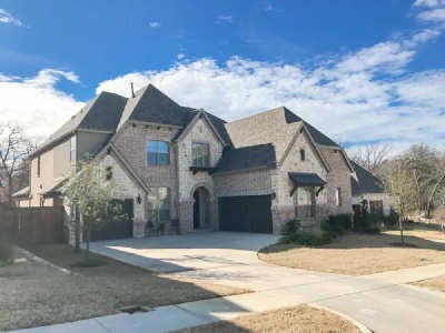 view of a large two garage, two story brick house