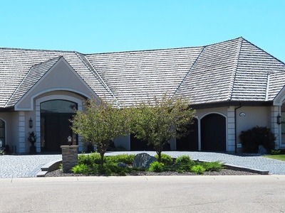 house with a half circle driveway and a little island in the center 