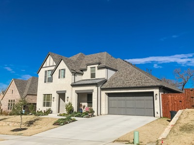 white house with a grey accent. photo taken from the street facing the garage.