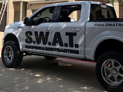 SWAT roofing white truck parked in a driveway