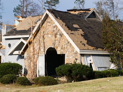 house with storm damage that needs to be repaired on the roof