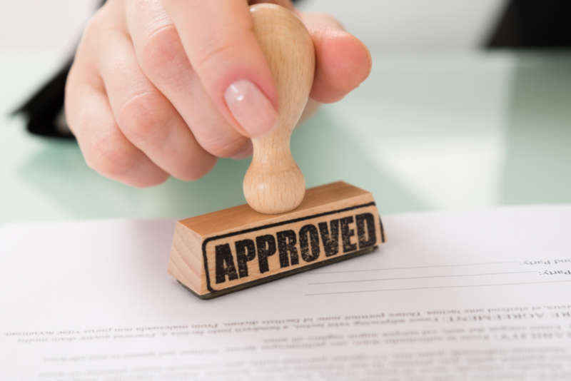 loan paperwork being stamped with approval