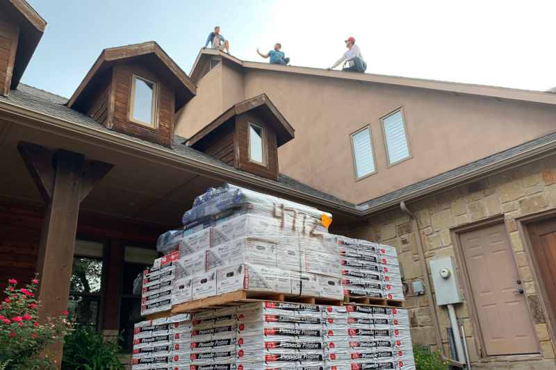 roofing contractors on top of roof getting ready to install new atlas pinnacle shingles